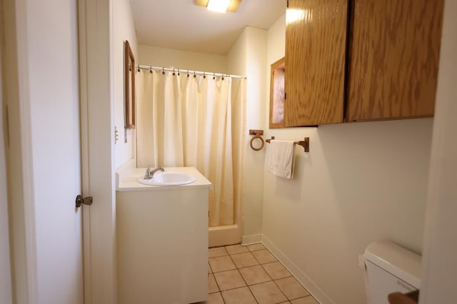 bathroom featuring toilet, tile patterned flooring, walk in shower, and sink