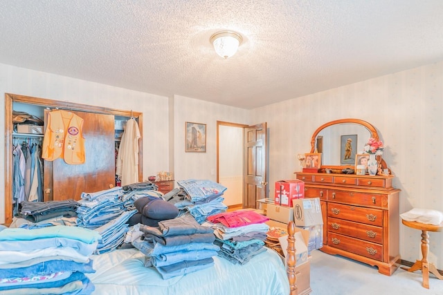 bedroom featuring a textured ceiling, a closet, and light carpet