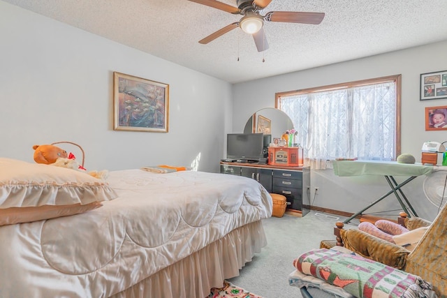 carpeted bedroom with ceiling fan and a textured ceiling