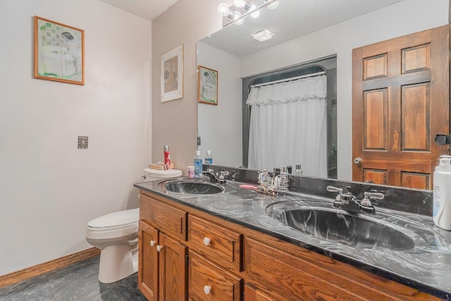 bathroom featuring toilet, vanity, and a textured ceiling