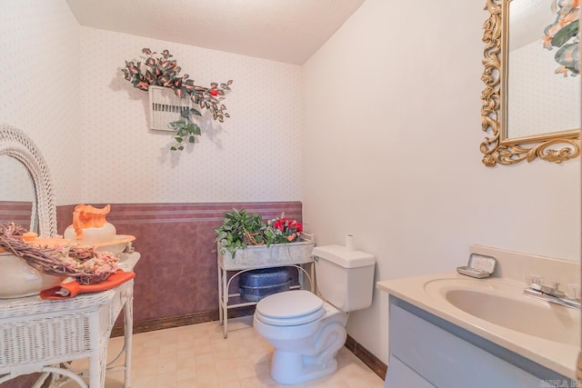 bathroom with a textured ceiling, toilet, and vanity