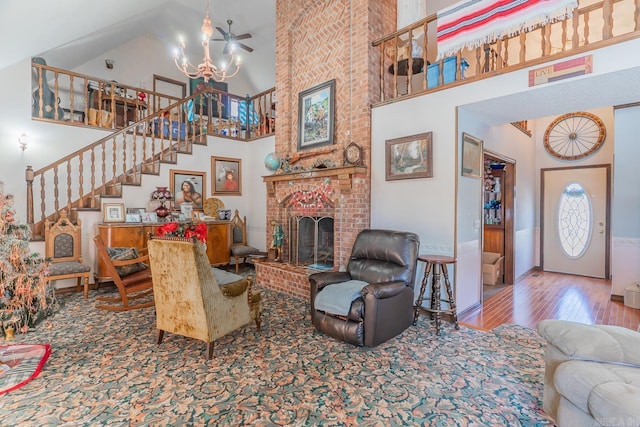 living room with a chandelier, a fireplace, hardwood / wood-style flooring, and high vaulted ceiling