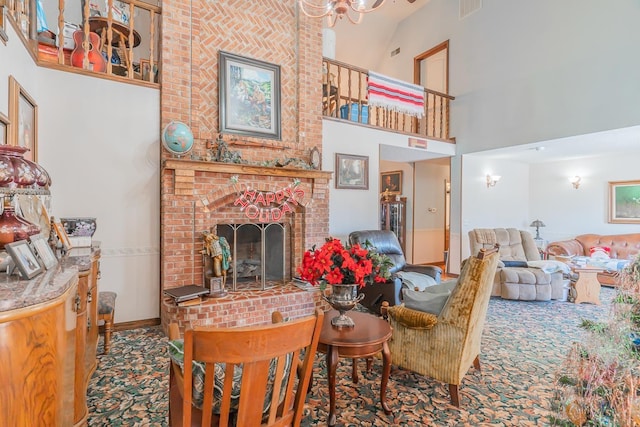 living room with a towering ceiling and a brick fireplace