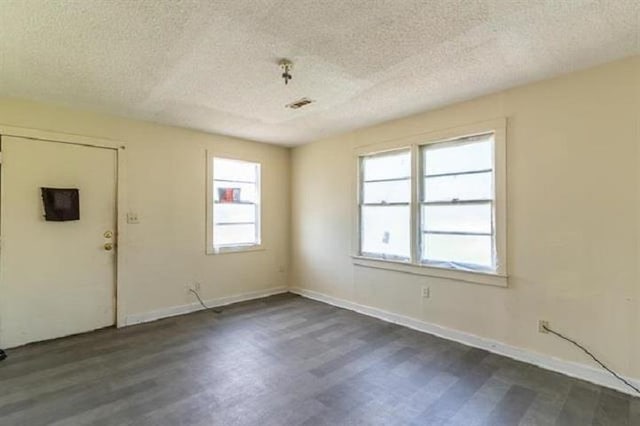 unfurnished room featuring a textured ceiling and dark hardwood / wood-style flooring