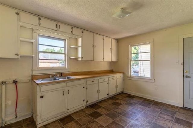 kitchen with sink, white cabinetry, and a textured ceiling