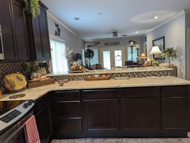 kitchen with kitchen peninsula, backsplash, electric stove, french doors, and ornamental molding