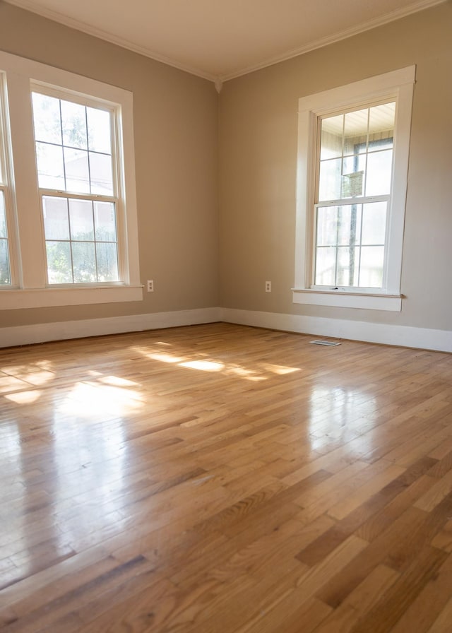 unfurnished room with crown molding and light hardwood / wood-style flooring