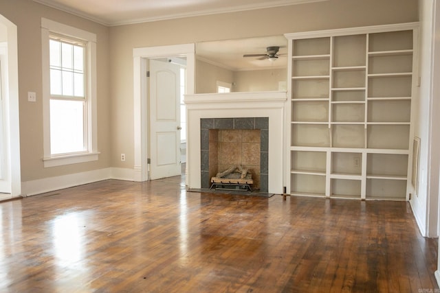 unfurnished living room featuring ceiling fan, a wealth of natural light, a fireplace, and dark hardwood / wood-style floors