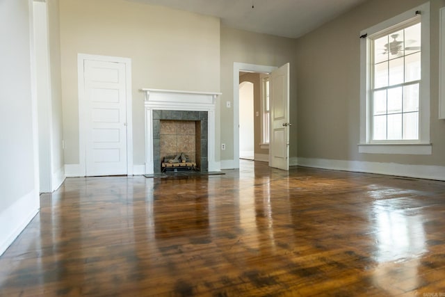 unfurnished living room featuring ceiling fan and a tile fireplace