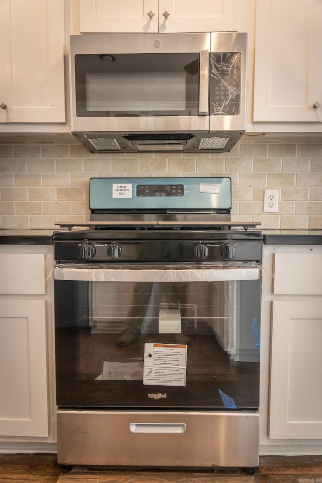 kitchen featuring appliances with stainless steel finishes, white cabinets, and tasteful backsplash