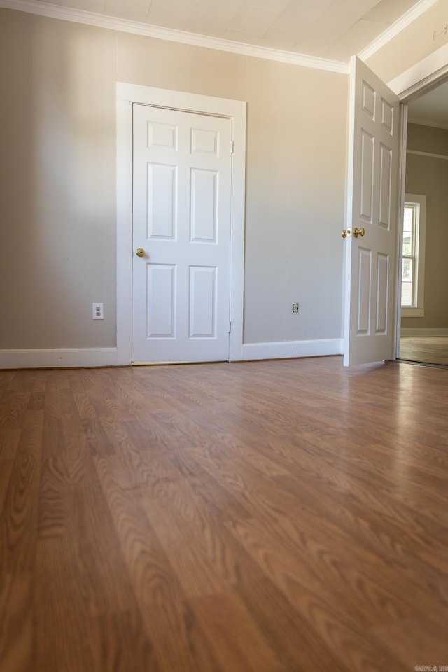 unfurnished bedroom with crown molding and hardwood / wood-style floors