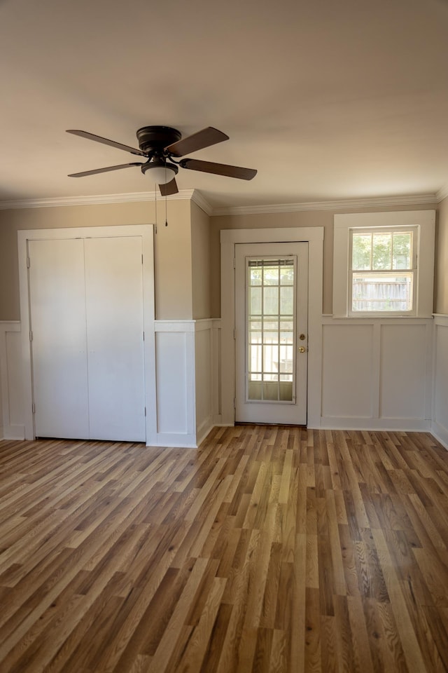 interior space with ceiling fan, ornamental molding, and hardwood / wood-style flooring