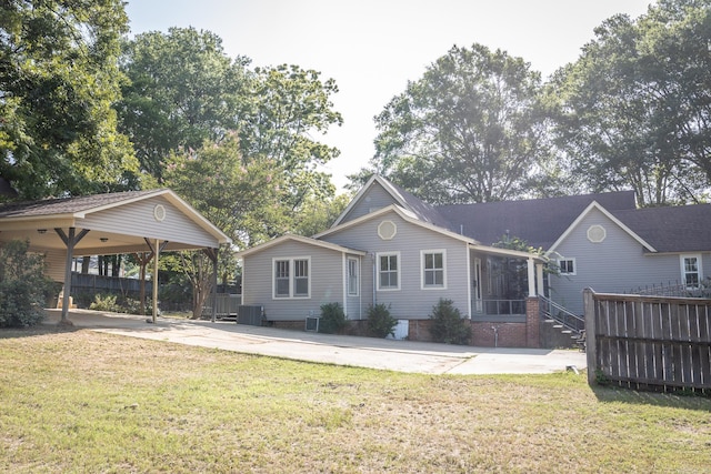 back of property featuring central air condition unit and a yard