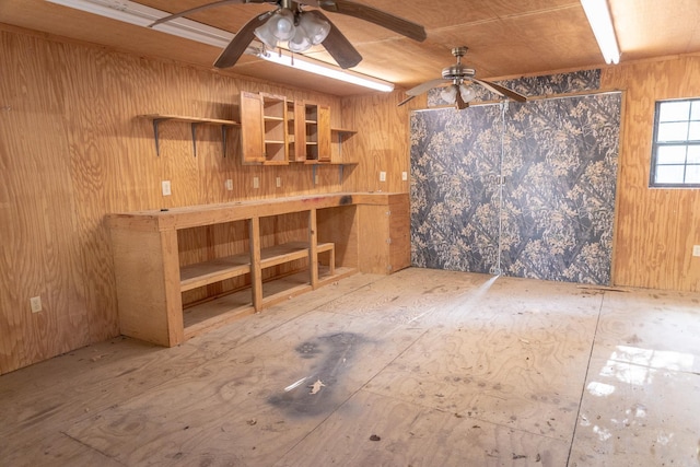 interior space featuring ceiling fan, wood ceiling, and wood walls