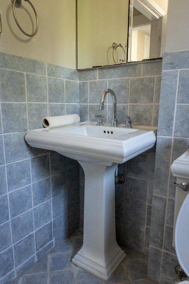 bathroom with tile walls, sink, and decorative backsplash