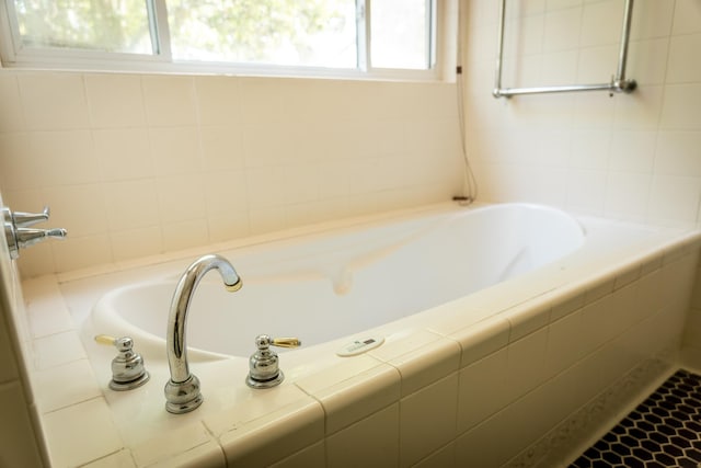 bathroom with a wealth of natural light and tiled tub