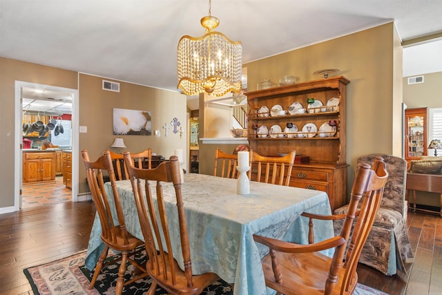 dining space with dark hardwood / wood-style flooring and a chandelier