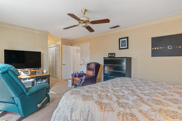 bedroom with light carpet, ceiling fan, crown molding, and two closets