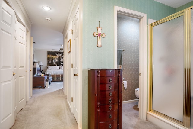 hallway featuring crown molding and light colored carpet