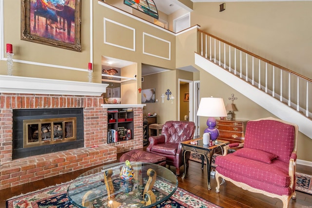 living room featuring a brick fireplace and hardwood / wood-style flooring