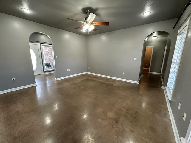 unfurnished room with ceiling fan and a wealth of natural light