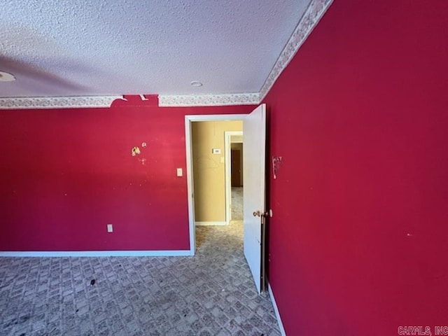 spare room featuring carpet and a textured ceiling