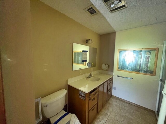 bathroom featuring a textured ceiling, toilet, and vanity