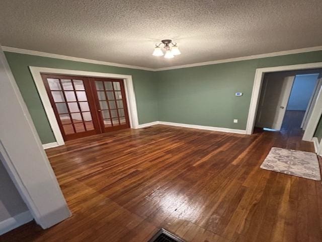 interior space with dark wood-type flooring, a textured ceiling, crown molding, and french doors