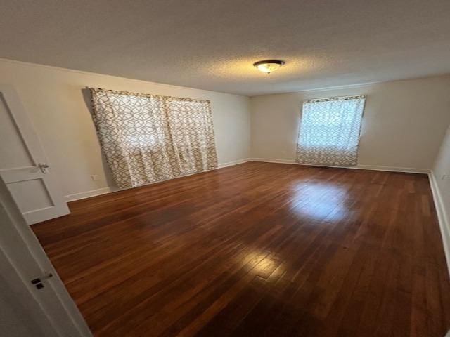 unfurnished room featuring a textured ceiling and dark hardwood / wood-style floors