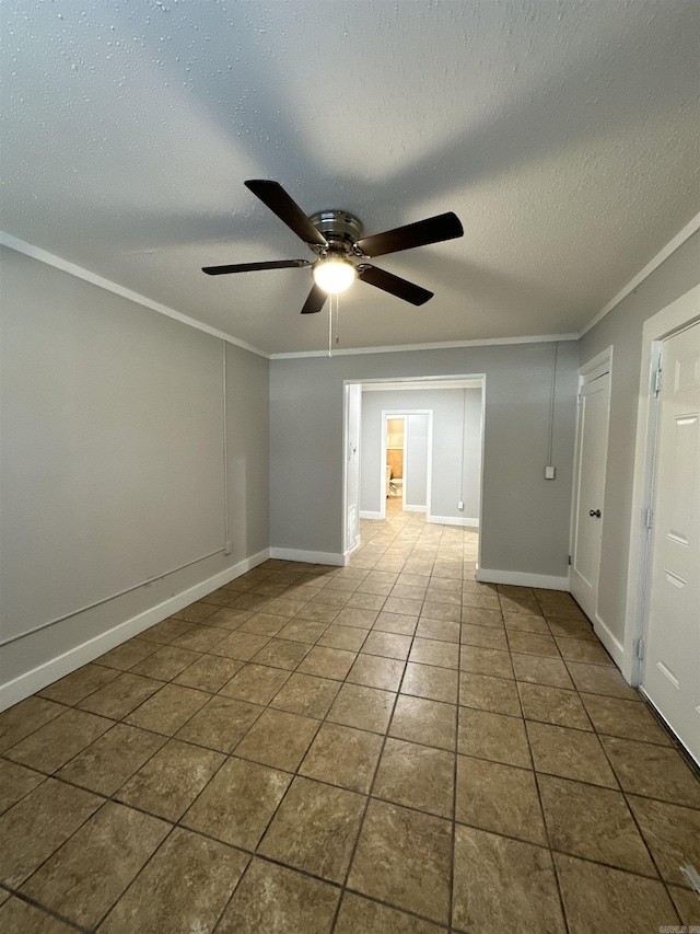 spare room with ceiling fan, a textured ceiling, tile patterned floors, and crown molding