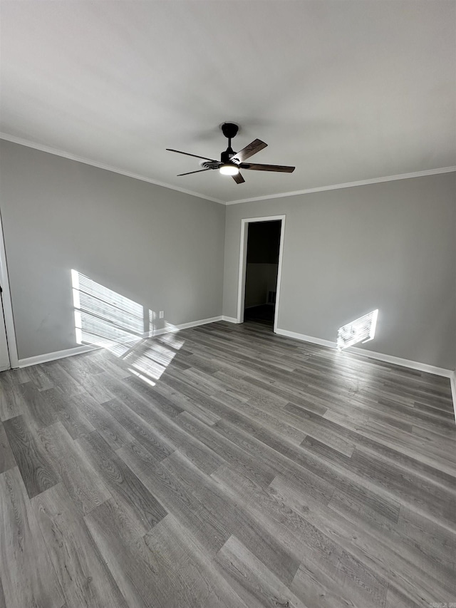 empty room with hardwood / wood-style flooring, ornamental molding, and ceiling fan