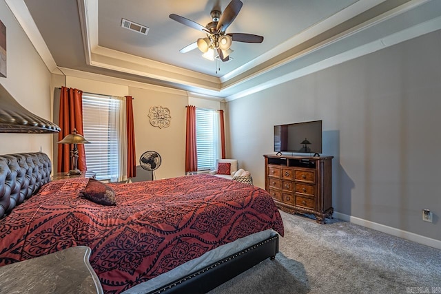 bedroom featuring ceiling fan, carpet, a tray ceiling, and ornamental molding