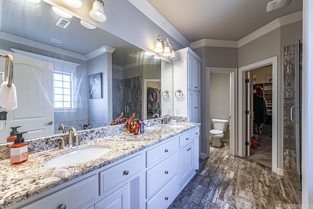 bathroom with toilet, vanity, a shower with door, and hardwood / wood-style flooring