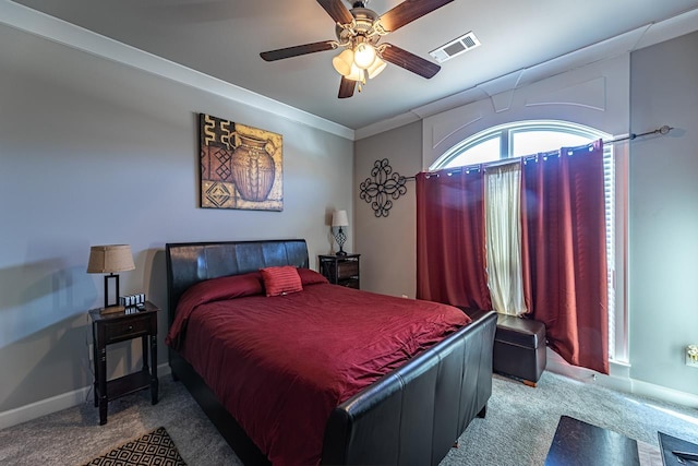 carpeted bedroom featuring ceiling fan and crown molding