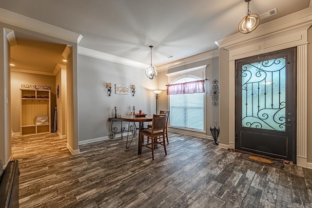 dining area with dark hardwood / wood-style flooring, crown molding, and an inviting chandelier