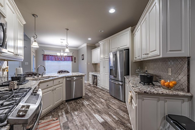 kitchen with white cabinets, pendant lighting, appliances with stainless steel finishes, and sink