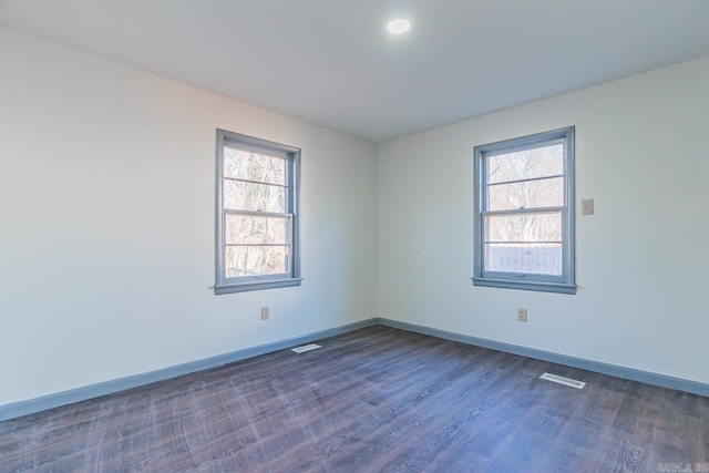 unfurnished room with dark wood-type flooring and a wealth of natural light