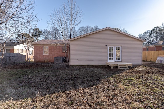 rear view of property featuring a lawn and cooling unit