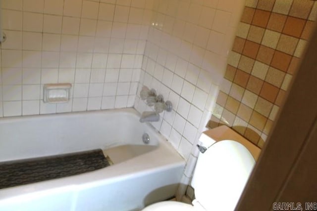 bathroom with toilet and tiled shower / bath combo