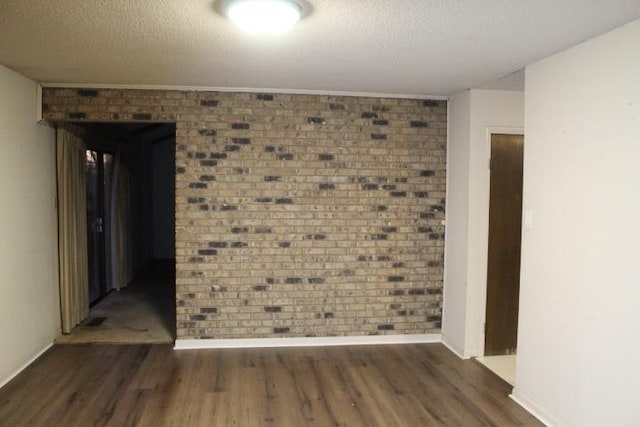 empty room with dark wood-type flooring and a textured ceiling