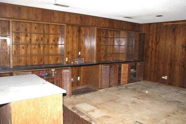 kitchen featuring a textured ceiling and wood walls