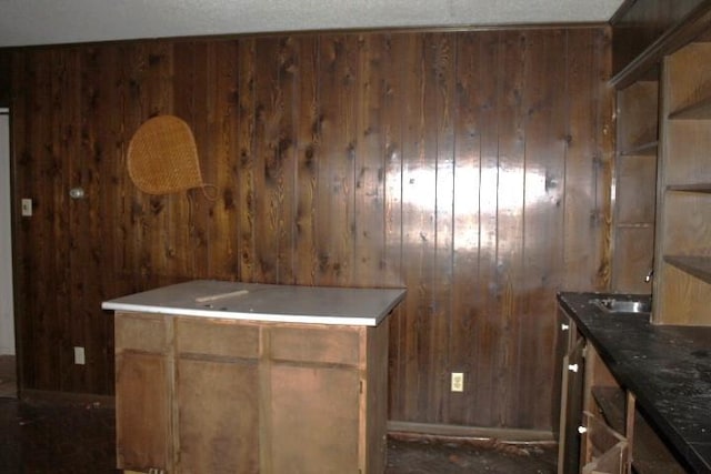 kitchen featuring a textured ceiling and wood walls