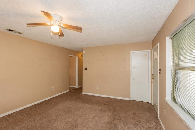 spare room with ceiling fan, a textured ceiling, and carpet flooring