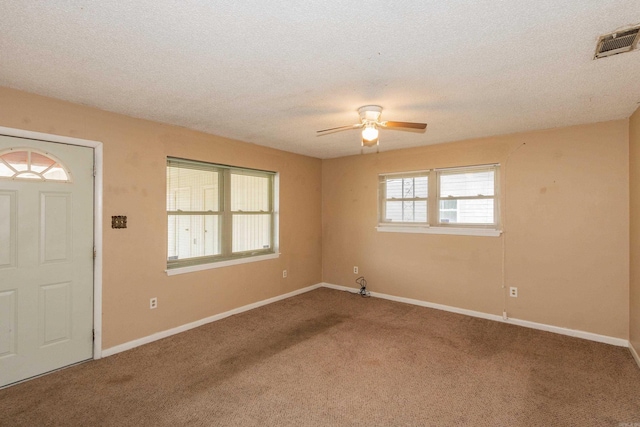 empty room with carpet floors, a textured ceiling, and ceiling fan