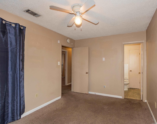 unfurnished bedroom featuring ceiling fan, carpet, ensuite bathroom, and a textured ceiling