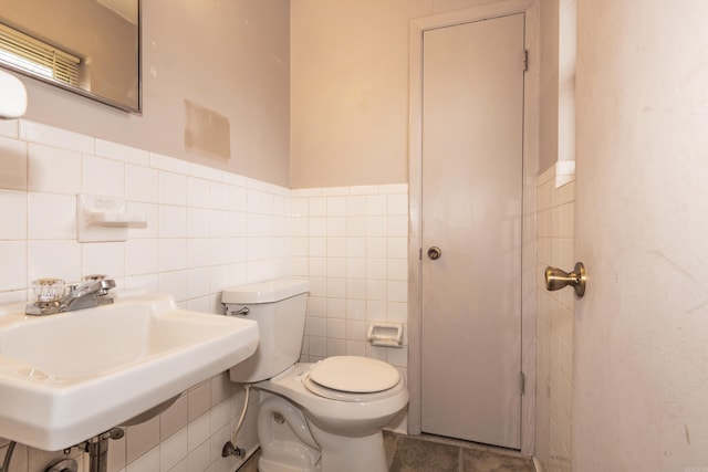 bathroom with sink, tile walls, toilet, and tile patterned flooring