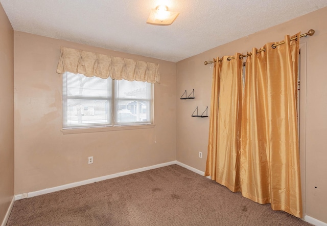 empty room with a textured ceiling and carpet flooring