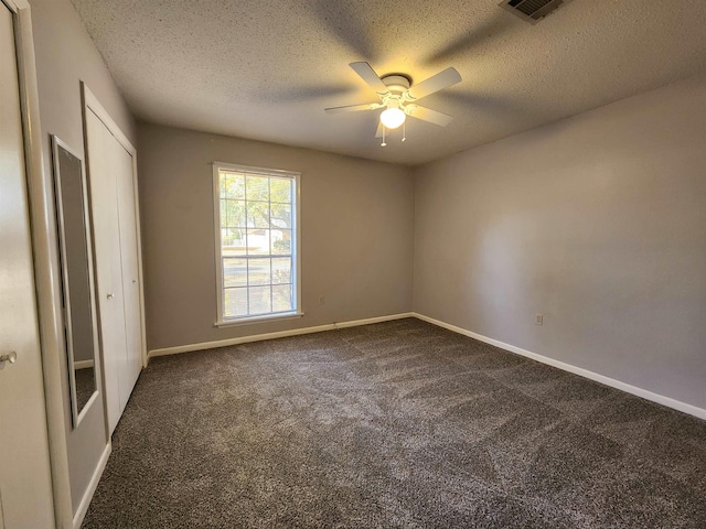 carpeted empty room featuring ceiling fan and a textured ceiling