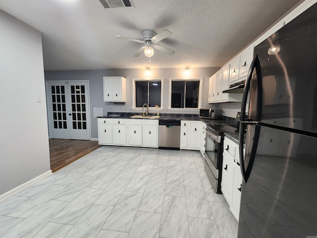 kitchen featuring sink, white cabinetry, stainless steel appliances, a textured ceiling, and french doors