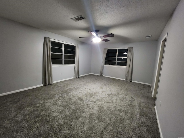 carpeted spare room featuring ceiling fan and a textured ceiling